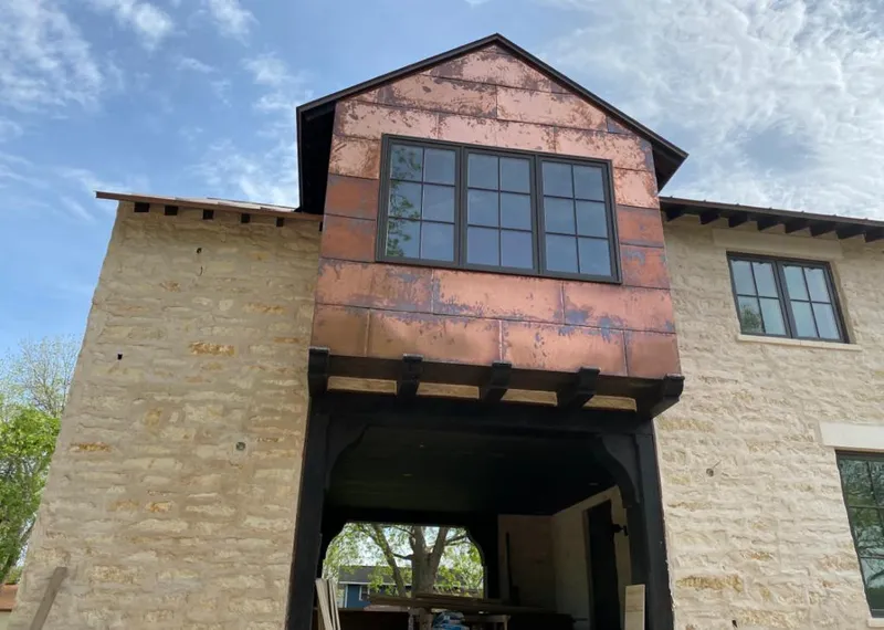 Copper metal panel facade on a stone building for Skylight Installation in Live Oak